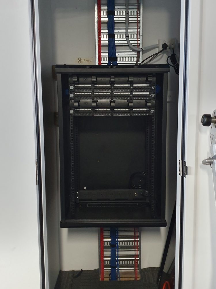 Wall-mounted comms rack during rough-in