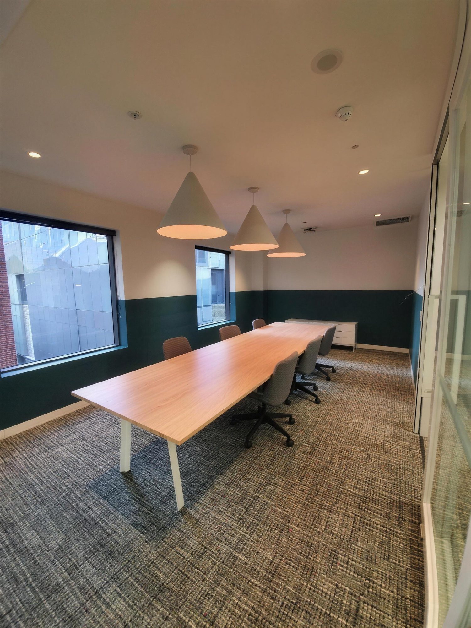 Boardroom with long timber table and pendant lighting at 189 Flinders Lane