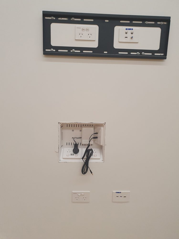 Wall-mounted screen bracket with AV wall plates below