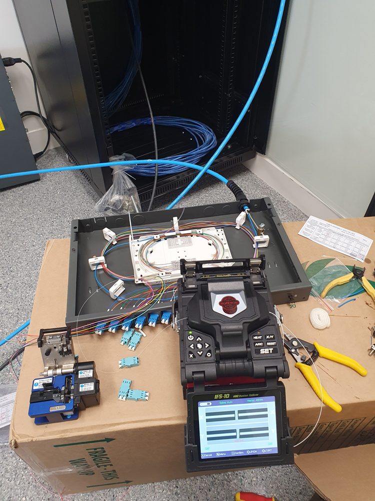 Fibre splicing machine and patch tray on a workbench