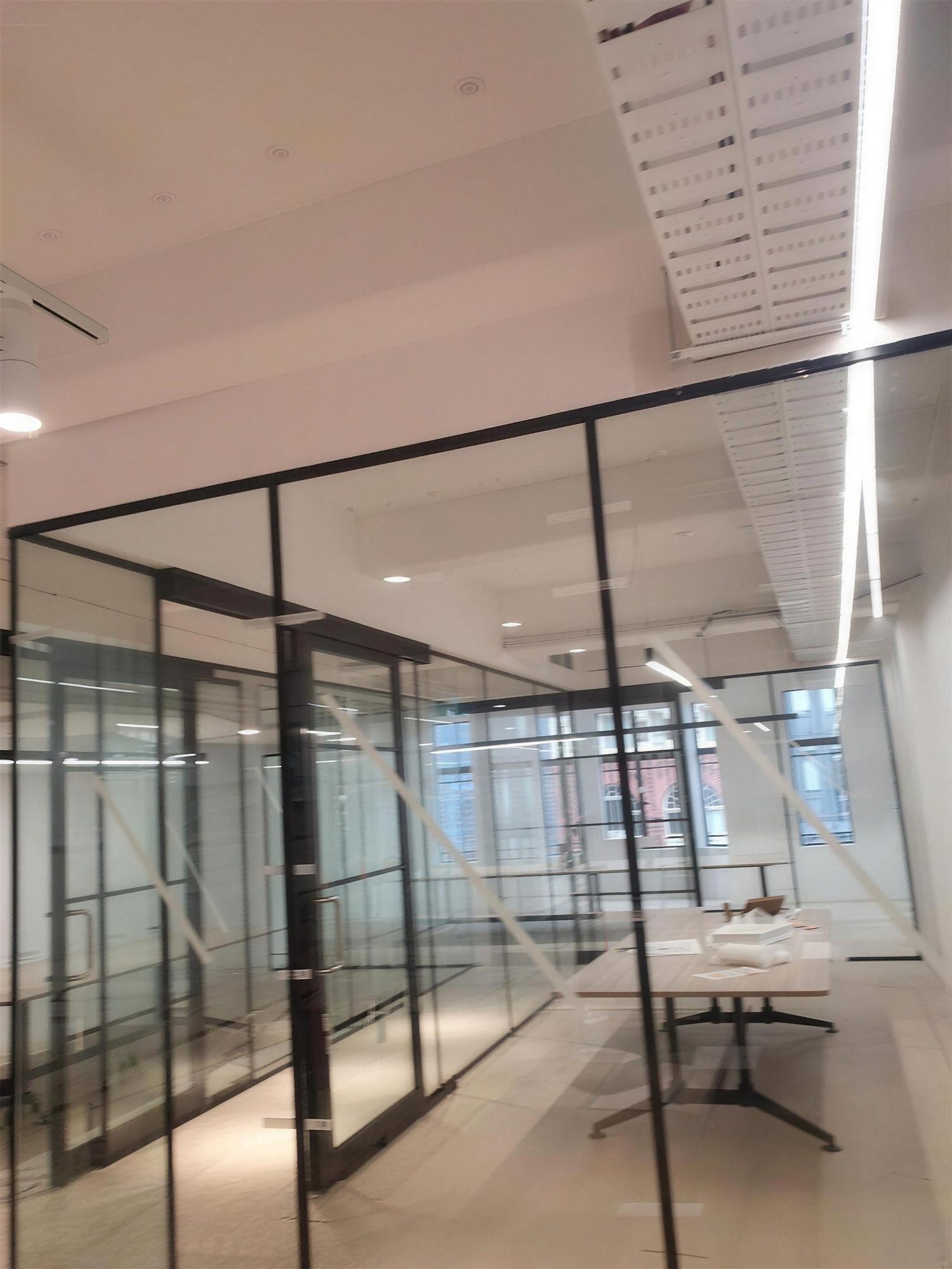Black-framed glazed meeting rooms with linear lighting