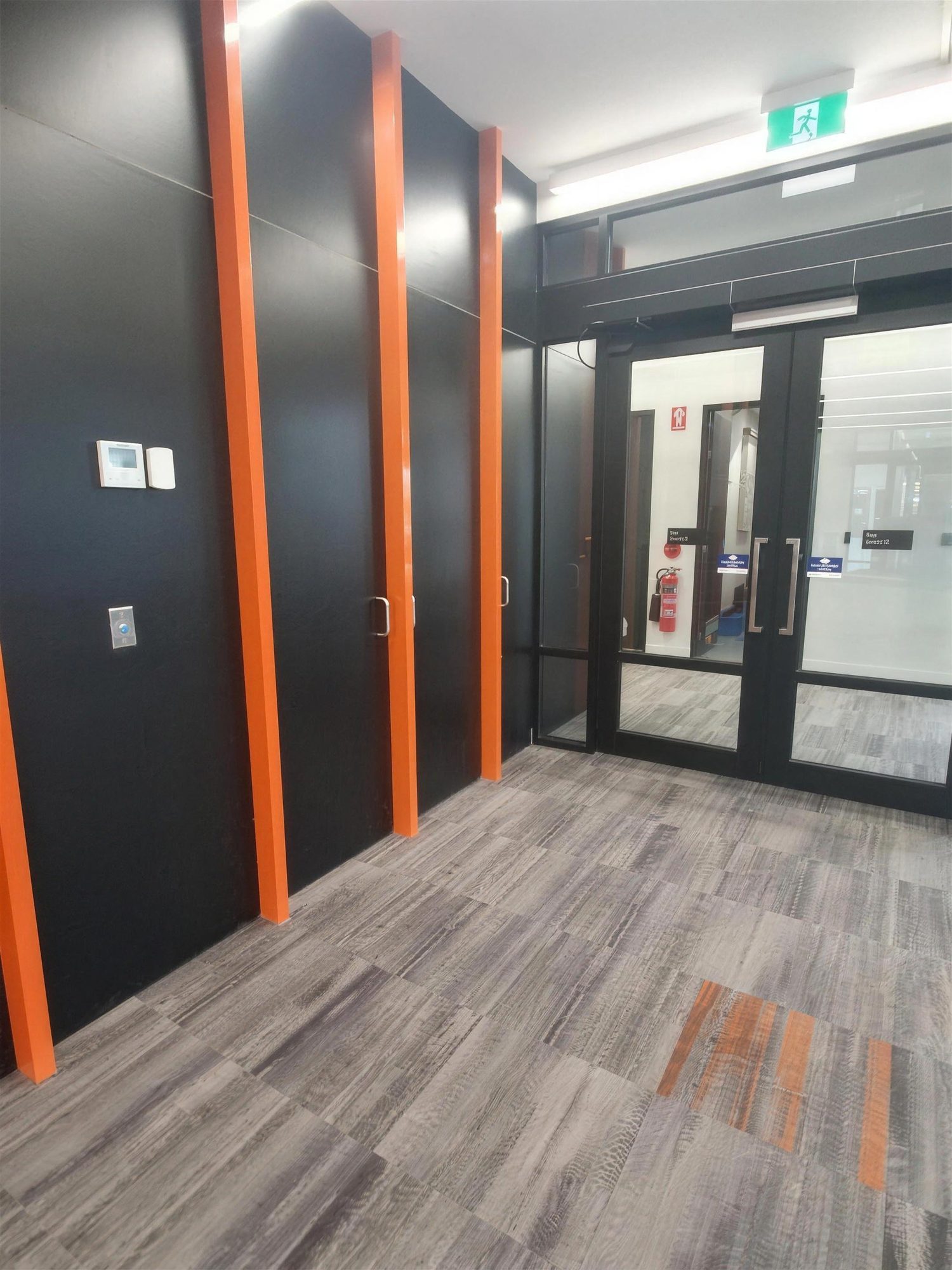 Corridor with orange door reveals and glazed entry doors